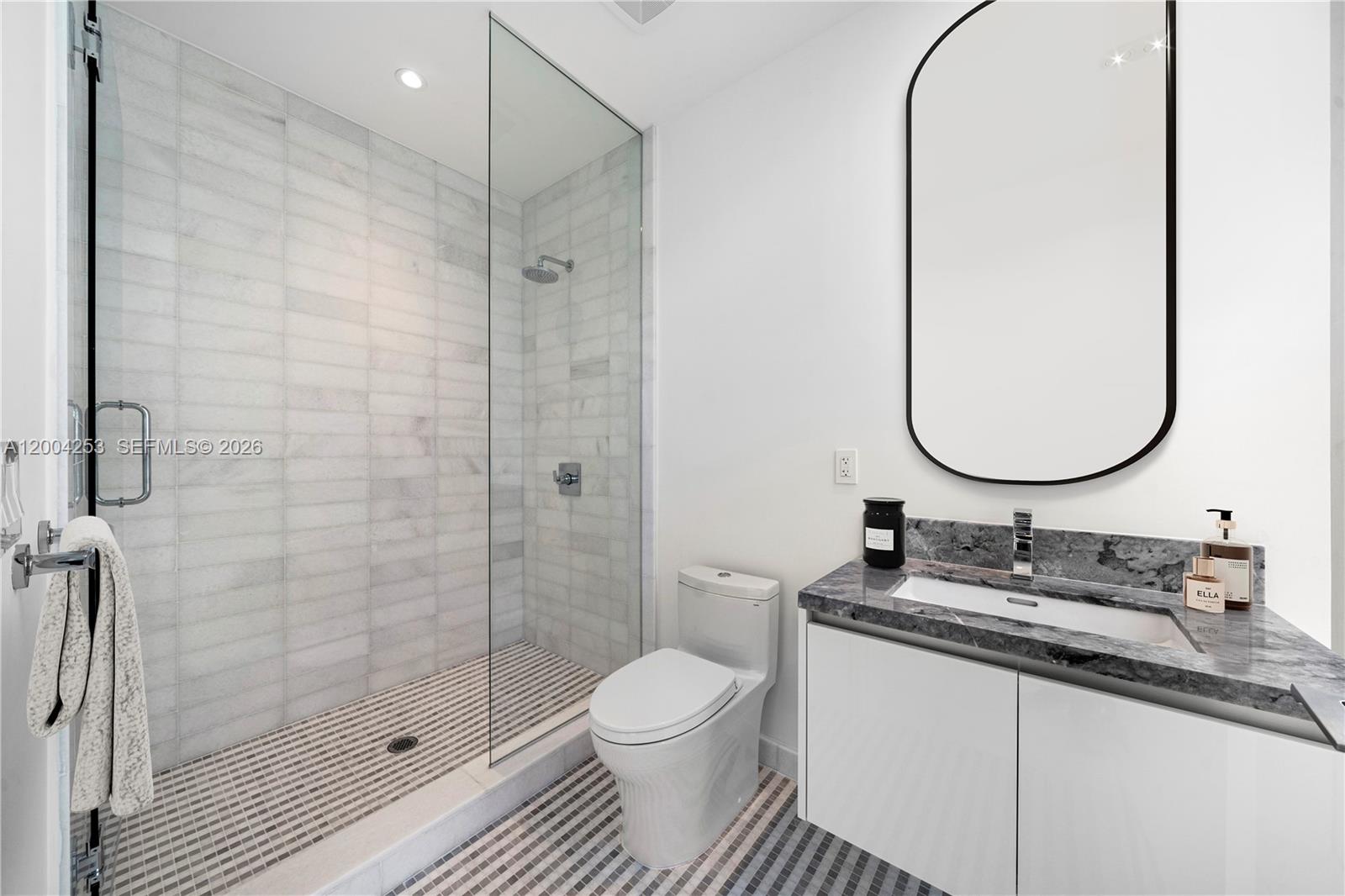 700 Northeast 26th Terrace, Unit TH403 Miami, FL 33137 - Photo 30 of 85 a bathroom with a sink vanity granite toilet and a mirror