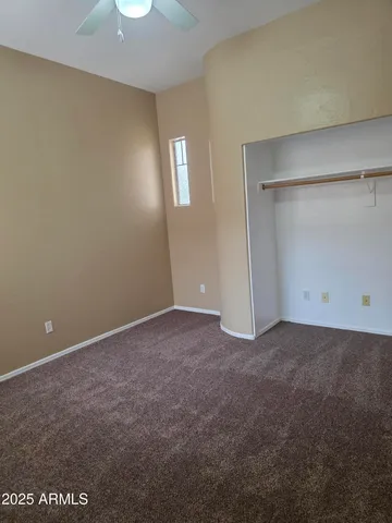 a view of an empty room with closet and a window