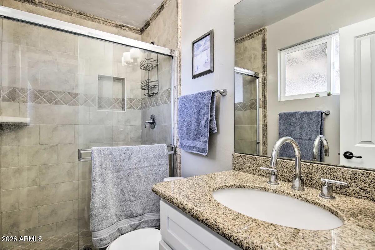 609 South Priest Drive Tempe, AZ 85281 - Photo 14 of 29 a bathroom with a granite countertop sink a toilet and shower