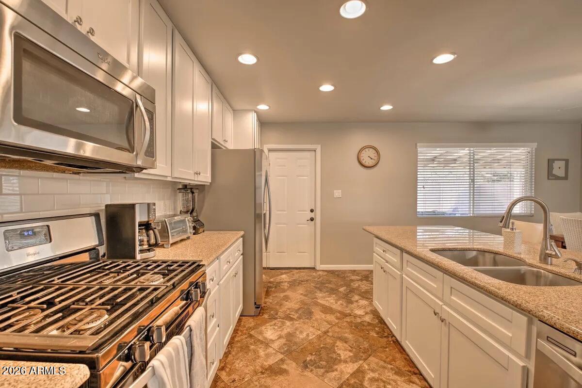 609 South Priest Drive Tempe, AZ 85281 - Photo 5 of 29 a kitchen with stainless steel appliances granite countertop a sink stove and cabinets