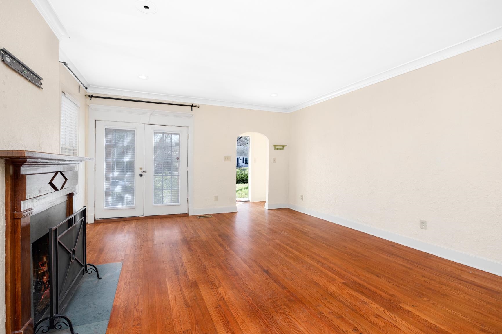 331 Alexander Street Memphis, TN 38111 - Photo 8 of 25 Unfurnished living room with arched walkways, hardwood / wood-style floors, ornamental molding, plenty of natural light, and french doors