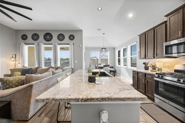 a kitchen with stainless steel appliances granite countertop a sink stove and cabinets