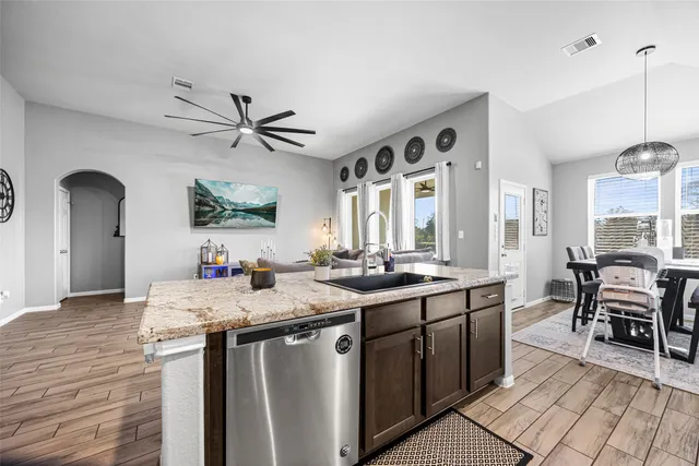 a kitchen with granite countertop a sink stove and refrigerator