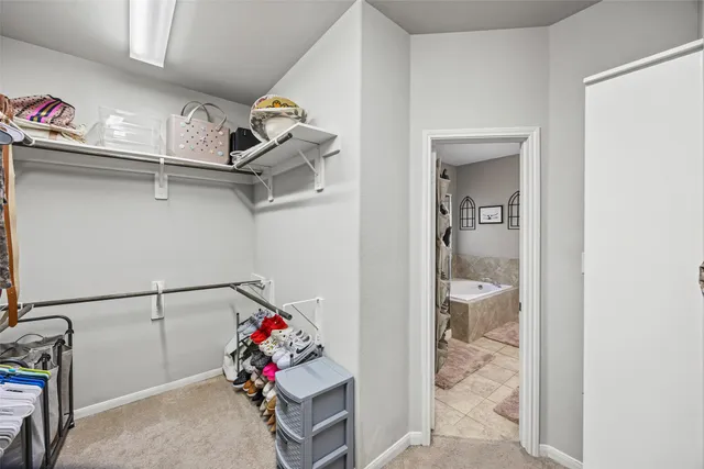a view of walk in closet with clothes and shoes