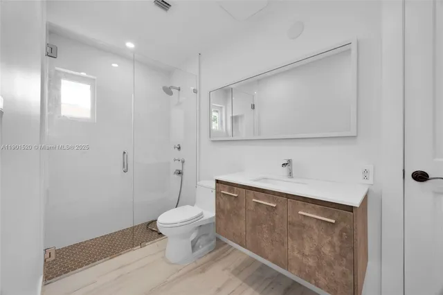 a bathroom with a sink a toilet and shower