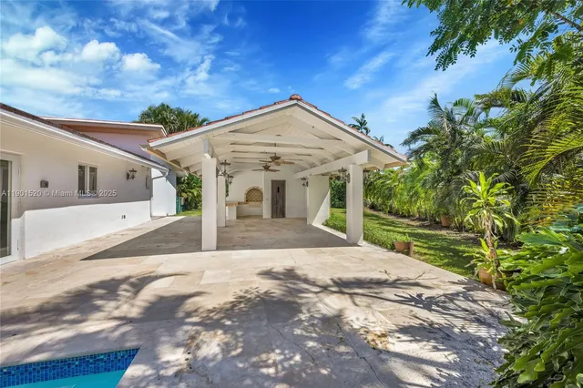 an aerial view of residential house with outdoor space and trees all around