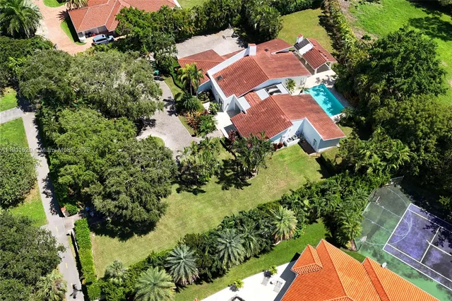 an aerial view of a house with a yard and swimming pool