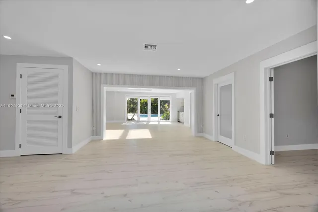 a view of a big room with wooden floor and windows