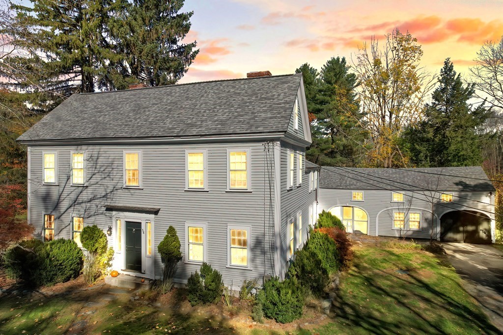 58 Hudson Road Sudbury, MA 01776 - Photo 1 of 42 a view of a brick house with a large windows and a table and chairs under an umbrella