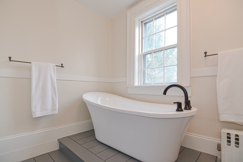 58 Hudson Road Sudbury, MA 01776 - Photo 30 of 42 a white bath tub sitting in a bathroom next to a window