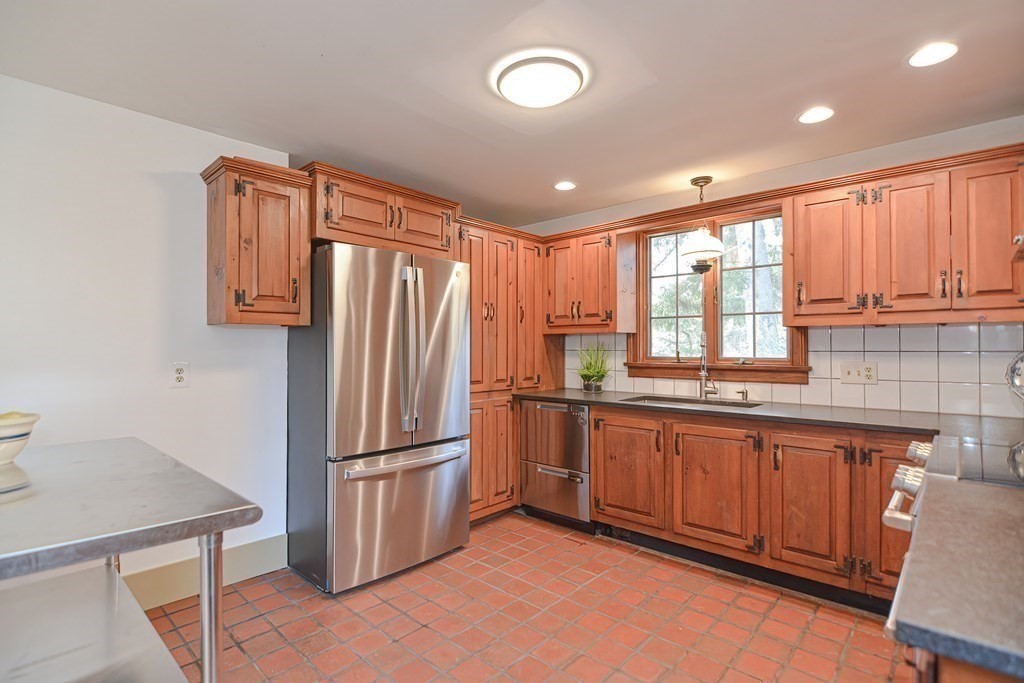 58 Hudson Road Sudbury, MA 01776 - Photo 7 of 42 a kitchen with stainless steel appliances granite countertop a refrigerator a sink dishwasher a stove with wooden cabinets and floor