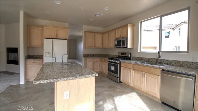 a kitchen with stainless steel appliances granite countertop a sink and a stove
