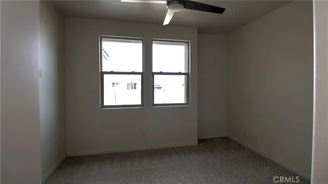 an empty room with closet and a chandelier fan