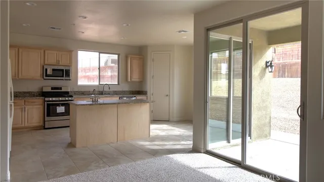 a kitchen with kitchen island granite countertop a stove a sink and a refrigerator