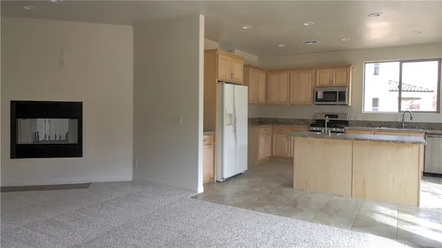 a kitchen with granite countertop white cabinets and stainless steel appliances
