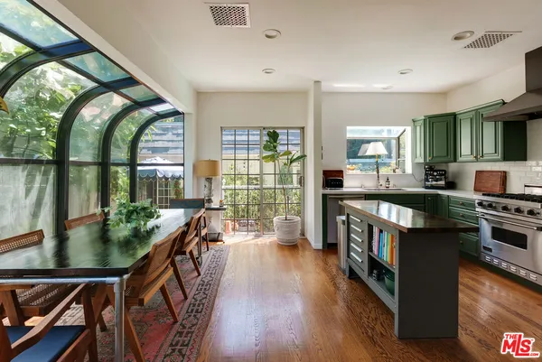 a open kitchen with stainless steel appliances granite countertop a stove and a wooden floors