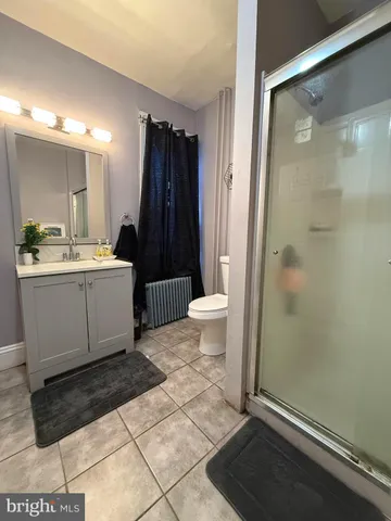 a bathroom with a sink a toilet a mirror and shower