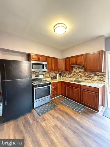 a kitchen with stainless steel appliances kitchen island granite countertop a sink stove and refrigerator