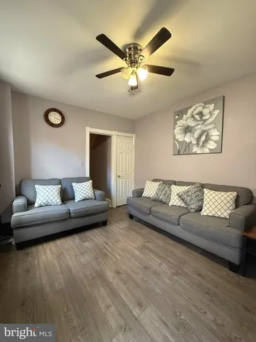 a living room with furniture and a ceiling fan