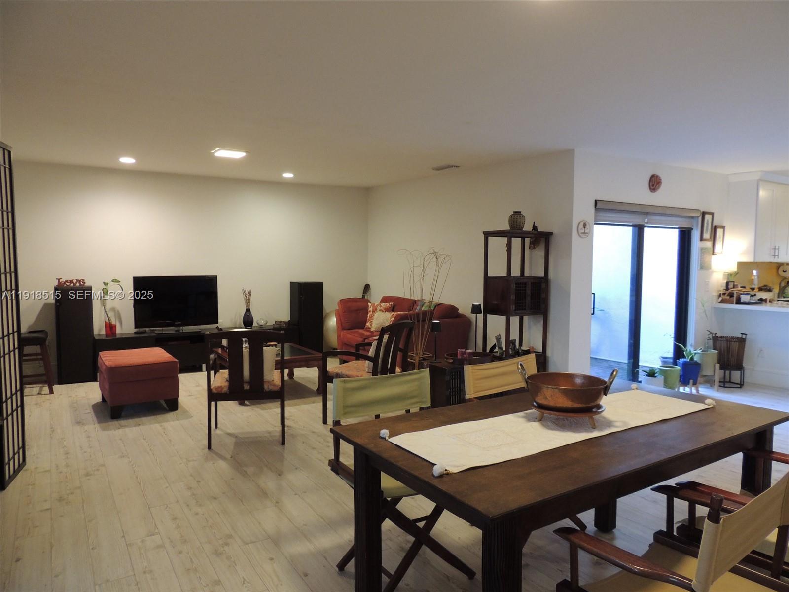 7951 Eastlake Drive, Unit C Boca Raton, FL 33433 - Photo 15 of 46 a living room with furniture a flat screen tv and kitchen view