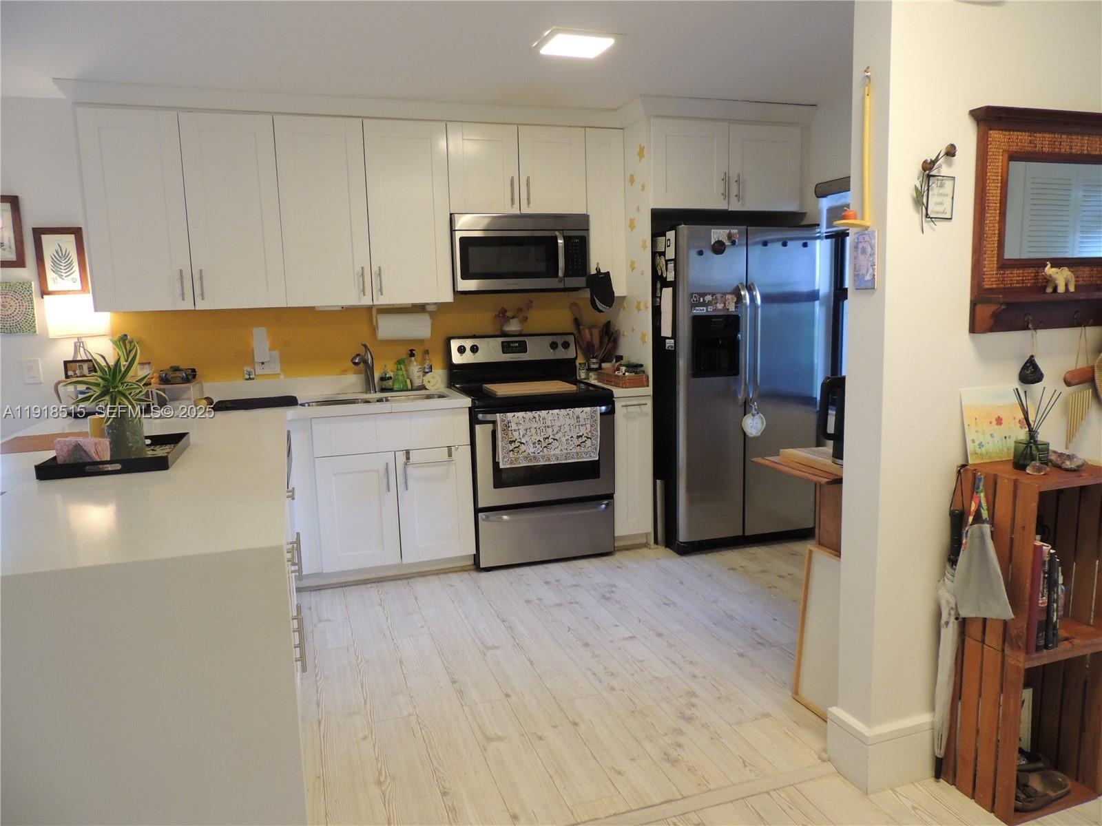 7951 Eastlake Drive, Unit C Boca Raton, FL 33433 - Photo 9 of 46 a kitchen with a sink stainless steel appliances and white cabinets