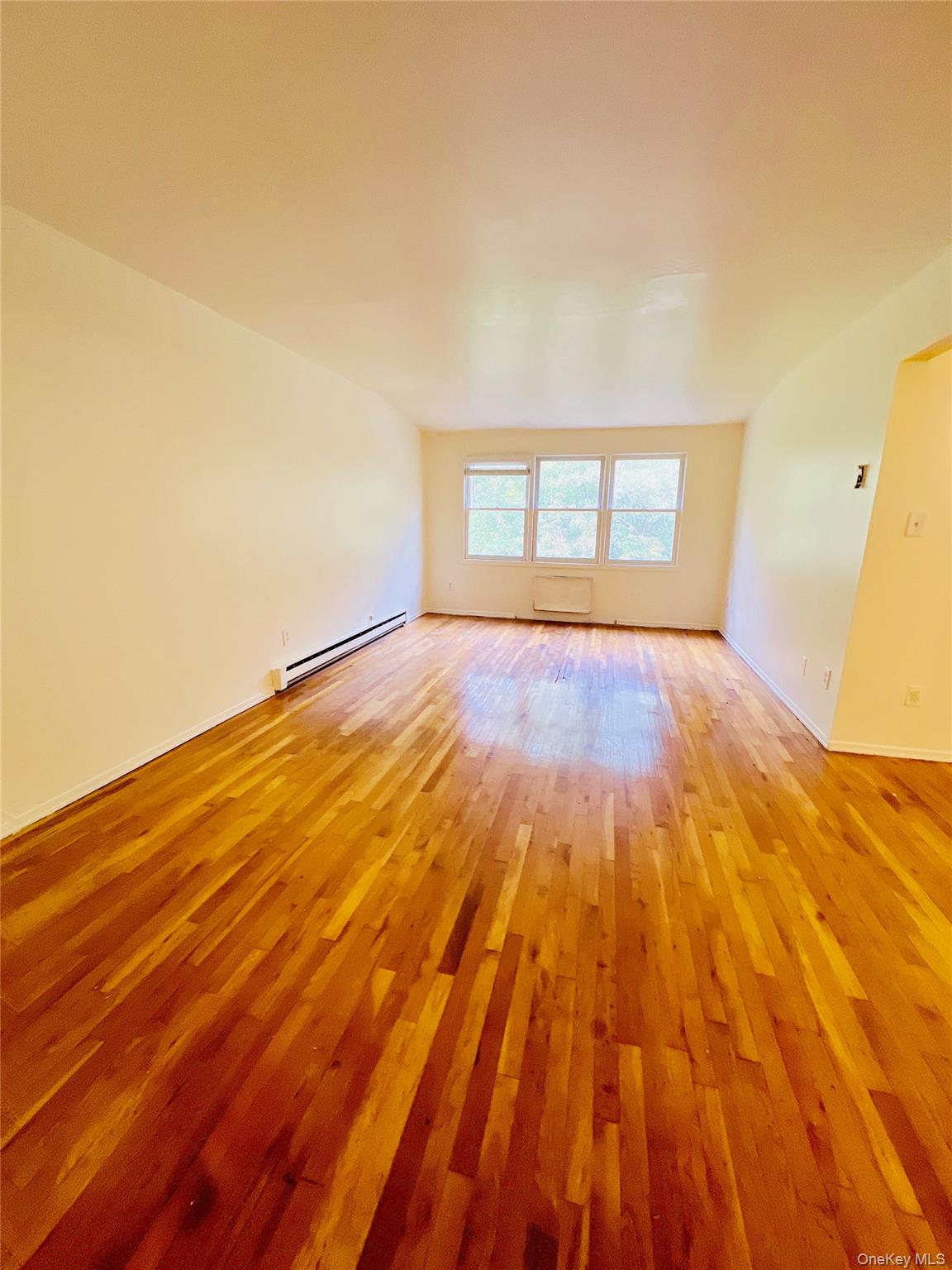 13-27 Bell Boulevard, Unit 3F Queens, NY 11360 - Photo 1 of 11 a view of empty room with wooden floor and fan