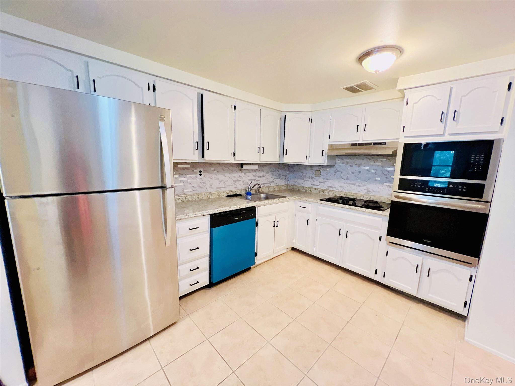 13-27 Bell Boulevard, Unit 3F Queens, NY 11360 - Photo 6 of 11 a kitchen with stainless steel appliances a refrigerator sink and cabinets