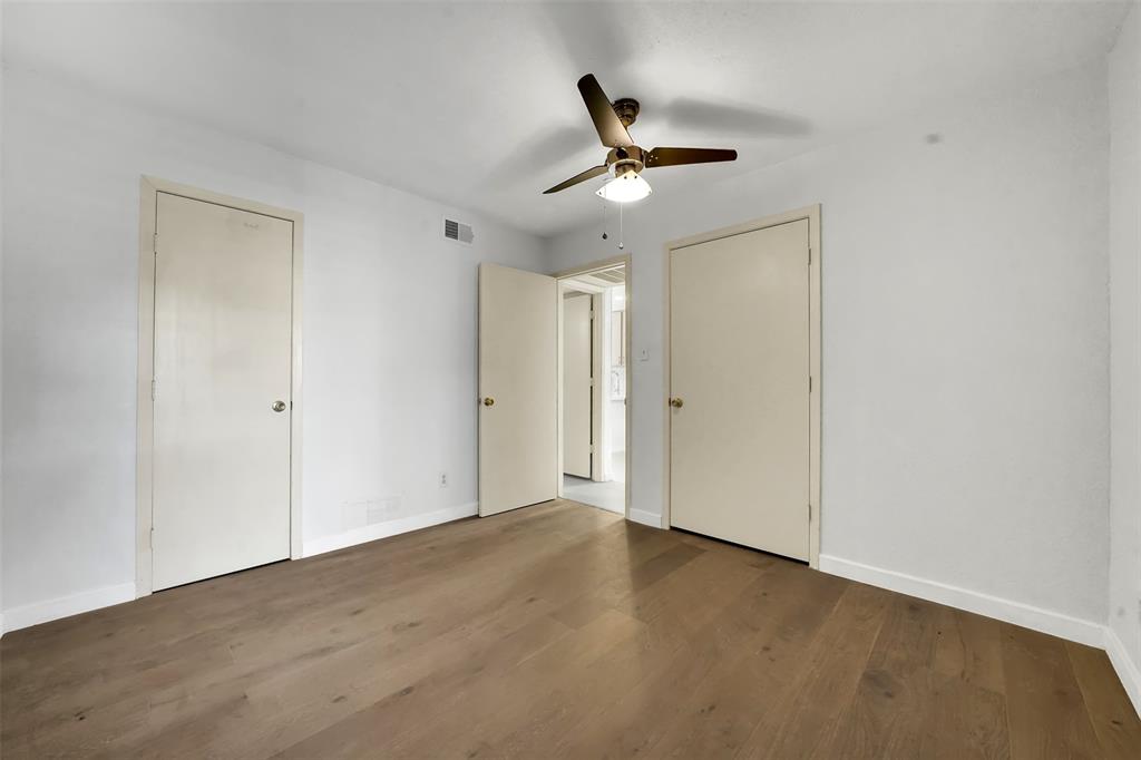 2111 East Belt Line Road, Unit 166B Richardson, TX 75081 - Photo 16 of 23 Unfurnished bedroom featuring dark wood-style flooring, two closets, and ceiling fan