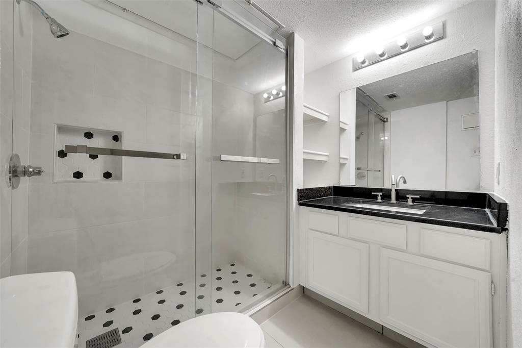 2111 East Belt Line Road, Unit 166B Richardson, TX 75081 - Photo 18 of 23 Bathroom with a textured ceiling, a stall shower, and vanity