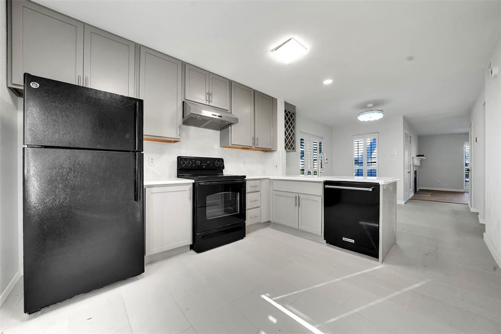 2111 East Belt Line Road, Unit 166B Richardson, TX 75081 - Photo 7 of 23 Kitchen featuring black appliances, gray cabinets, a peninsula, and under cabinet range hood