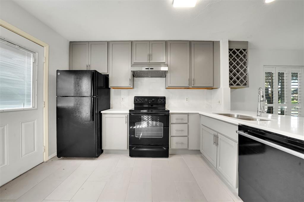 2111 East Belt Line Road, Unit 166B Richardson, TX 75081 - Photo 8 of 23 Kitchen featuring black appliances, gray cabinets, under cabinet range hood, and light stone counters