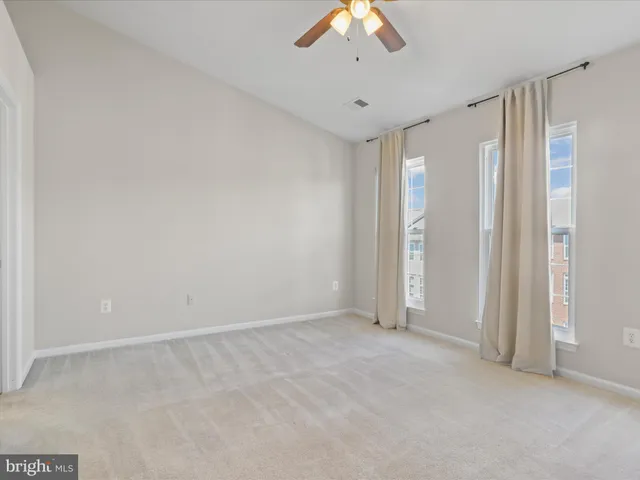 an empty room with closet and a chandelier fan