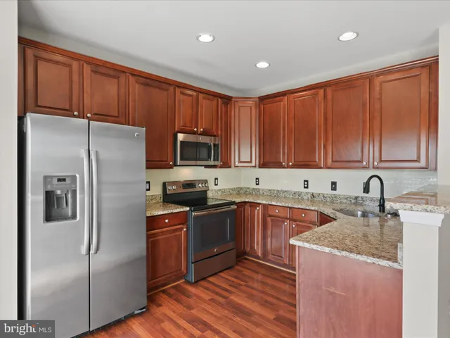 a kitchen with a refrigerator sink and cabinets