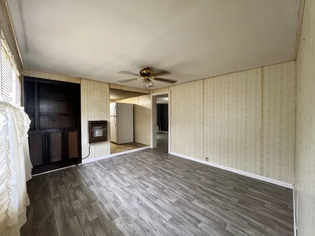 a view of empty room with wooden floor