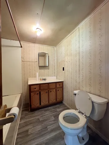 a bathroom with a granite countertop toilet sink and mirror
