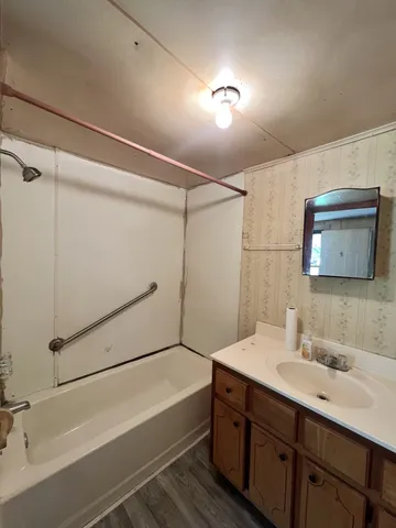 a bathroom with a sink mirror vanity and bathtub