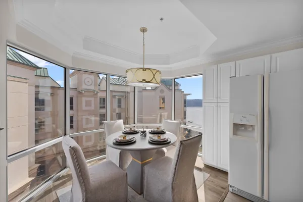 a large white kitchen with a large window and kitchen island