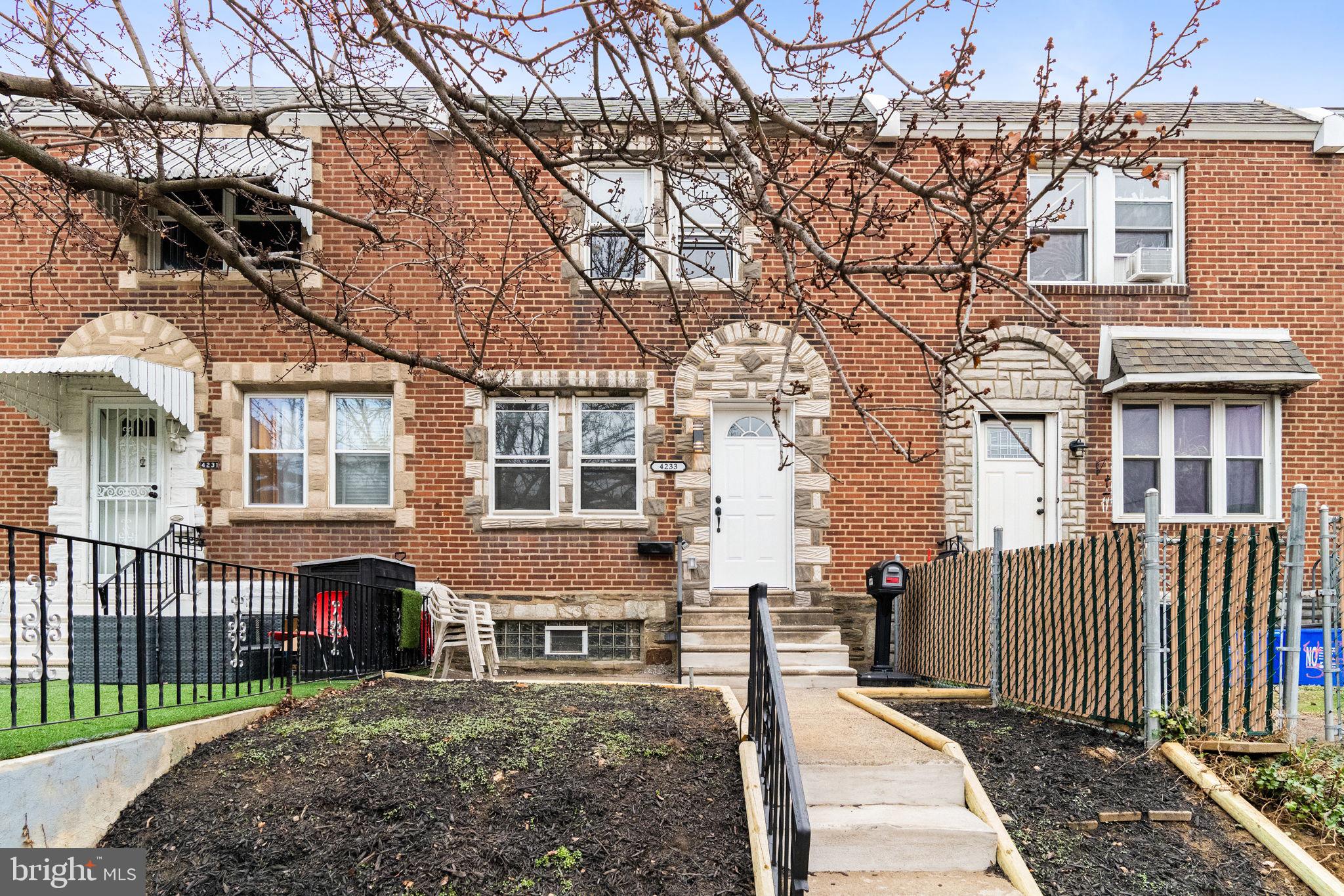 4233 Passmore Street Philadelphia, PA 19135 - Photo 28 of 30 a view of a brick house with large windows and a small yard