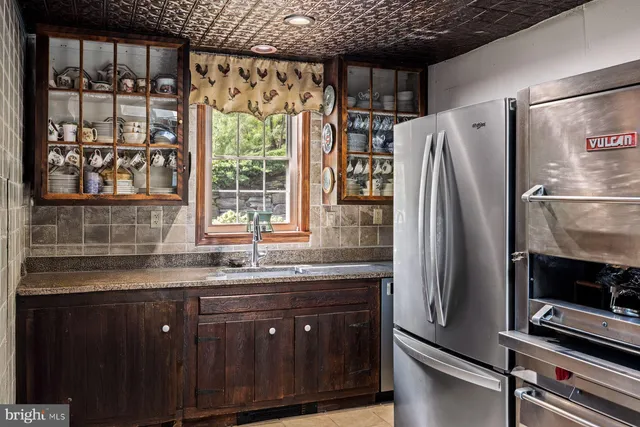 a kitchen with stainless steel appliances granite countertop a refrigerator and a sink
