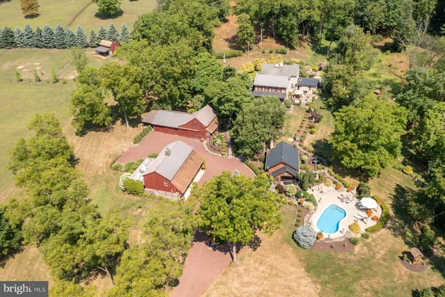an aerial view of a house with a yard and large trees