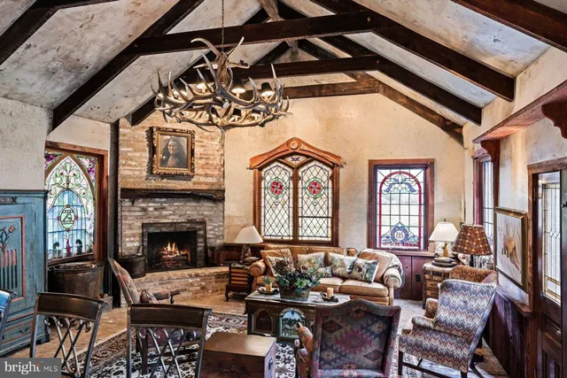 a living room with furniture a fireplace and a chandelier