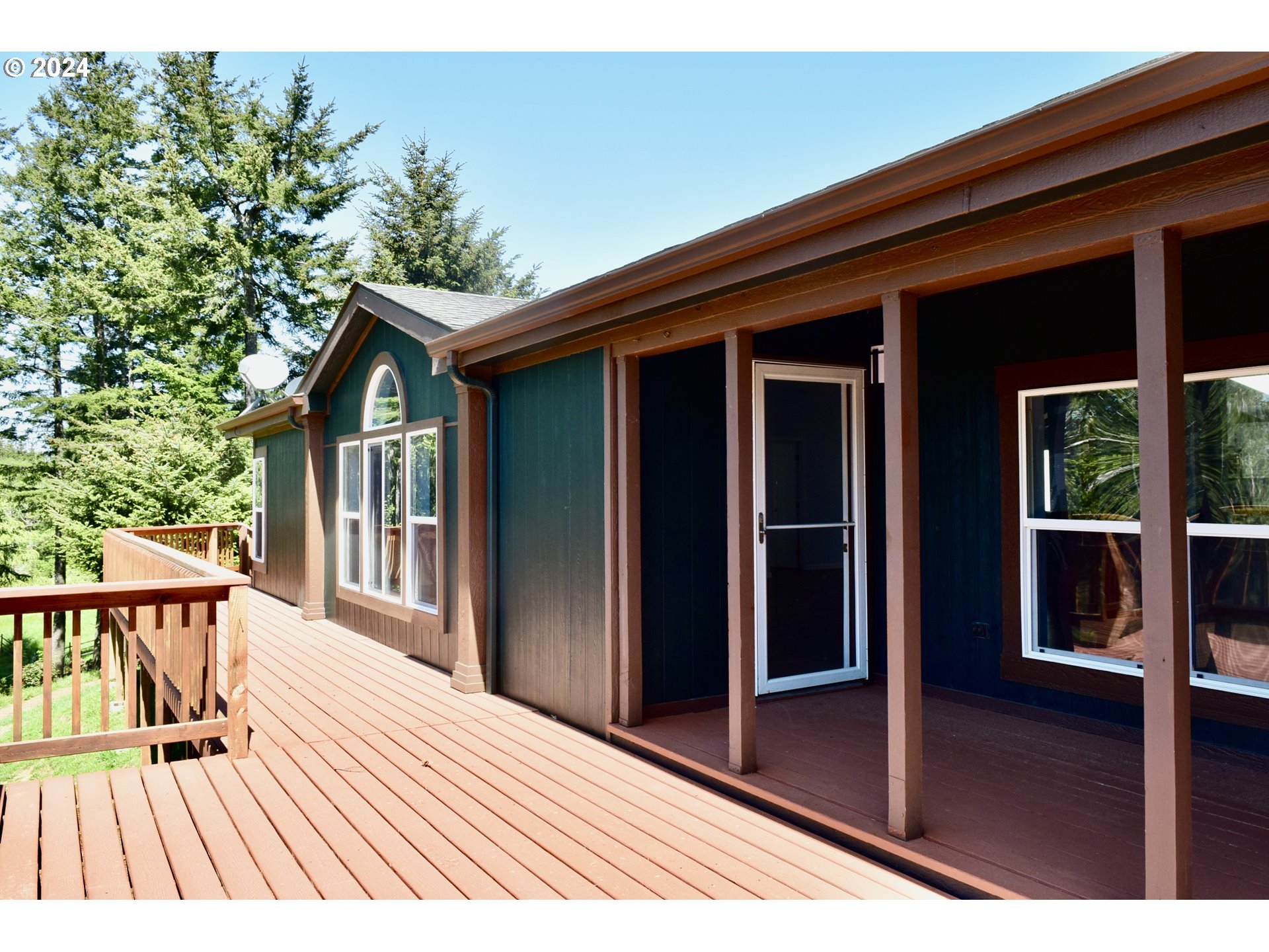 27286 Eighty Acres Road Gold Beach, OR 97444 - Photo 22 of 46 a view of backyard with large trees and wooden floor