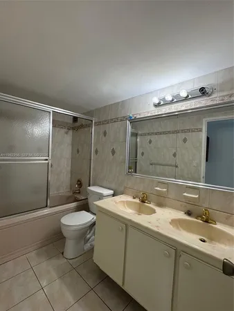a spacious bathroom with a granite countertop sink toilet a mirror and shower