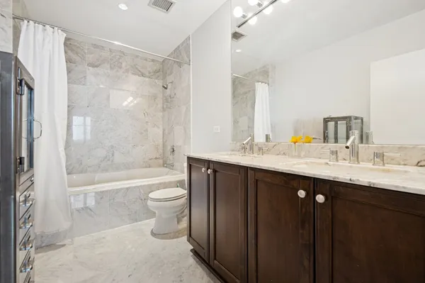 a bathroom with a double vanity sink toilet and shower