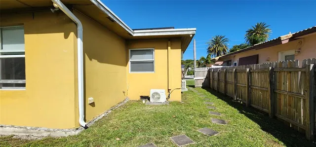 a view of a backyard with wooden fence