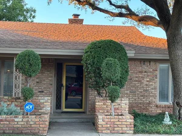 a front view of a house with a tree