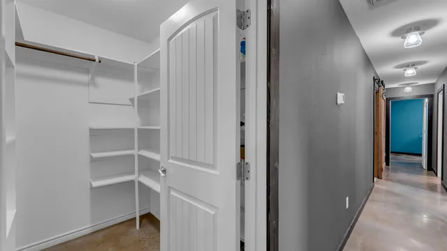 a view of walk in closet with empty racks