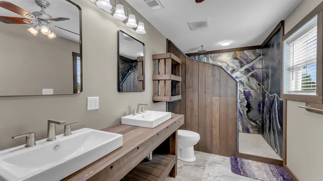 a bathroom with a sink a toilet and shower