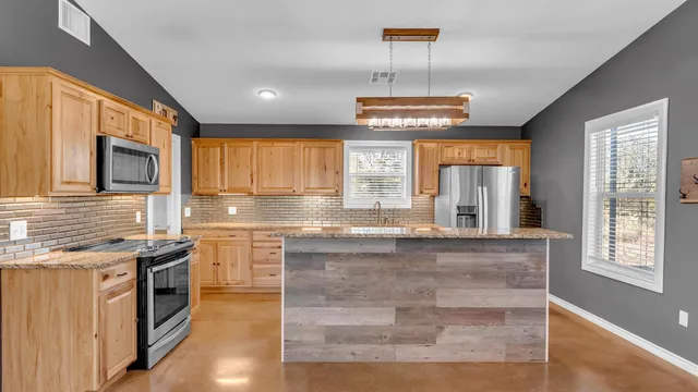 a large kitchen with stainless steel appliances granite countertop a stove and a sink