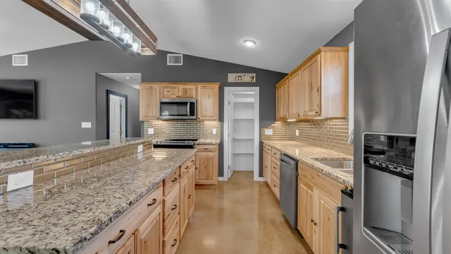 a kitchen with stainless steel appliances granite countertop a sink stove and refrigerator